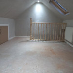 freshly plastered roof space conversion showing storage space in walls and radiator