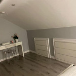 finished atic conversion showing floor in place with painted walls and furniture with in wall storage